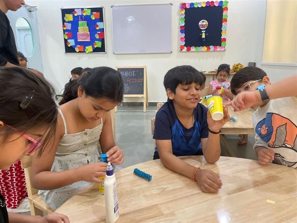 Children making paper-cup crafts together at an activity table