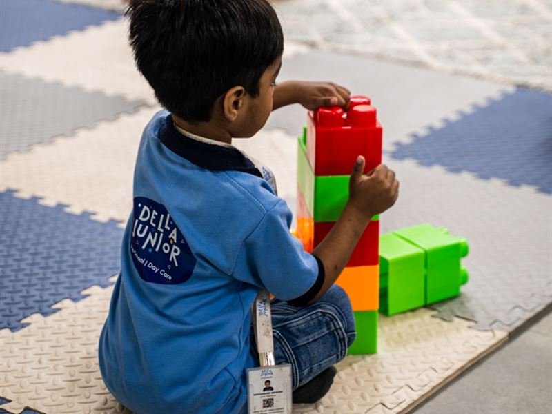 A toddler building a tower with big blocks