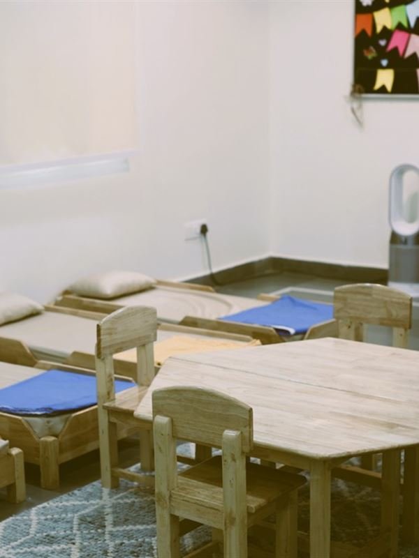 The daycare room with little beds and a play table