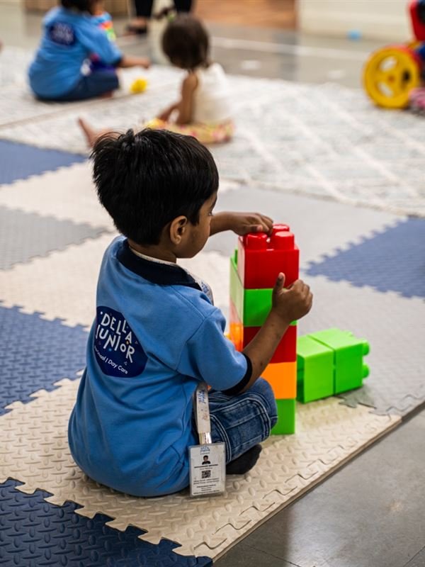 A toddler building a tower with big blocks